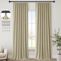 Beige curtains hanging in a room with a window, a plant, and a chair.